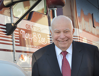 Tom Welge standing in front of a large shipping  truck