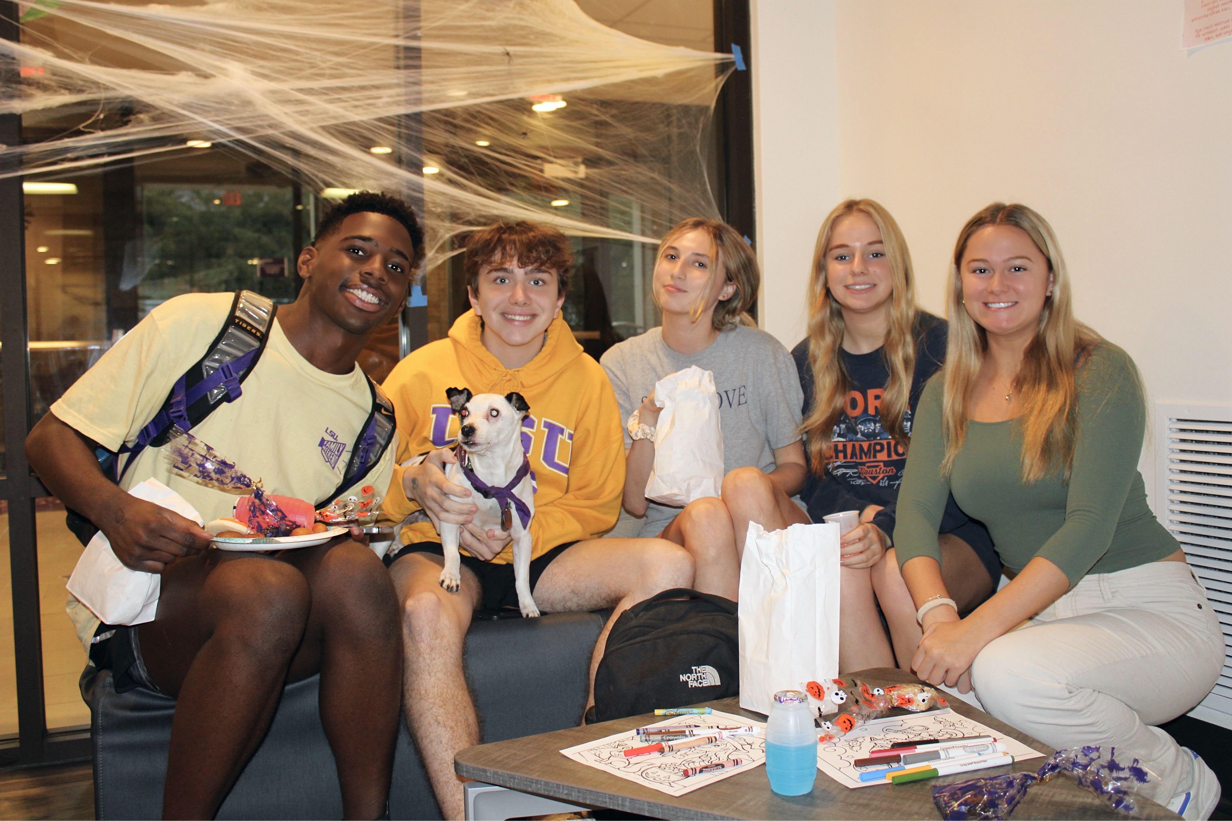 Group of students posing for a picture with a dog.