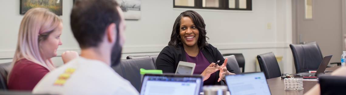 Memebers of the MEL Lab talking at a table.